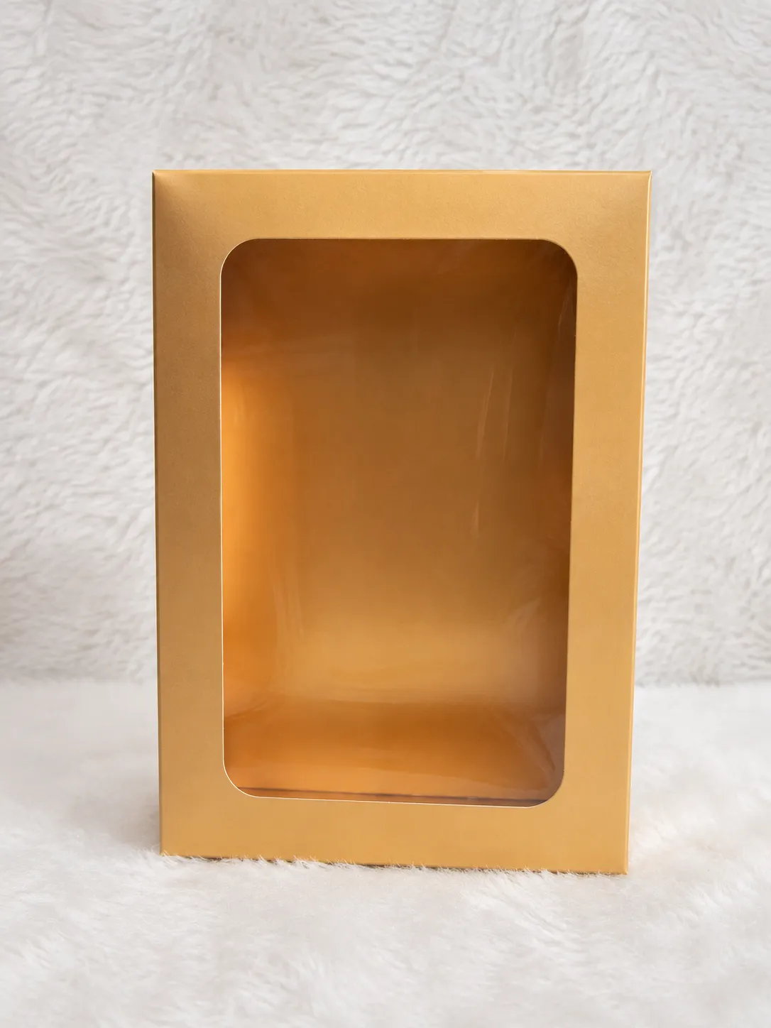  A bright golden box with a transparent window on the top, allowing visibility of the interior.