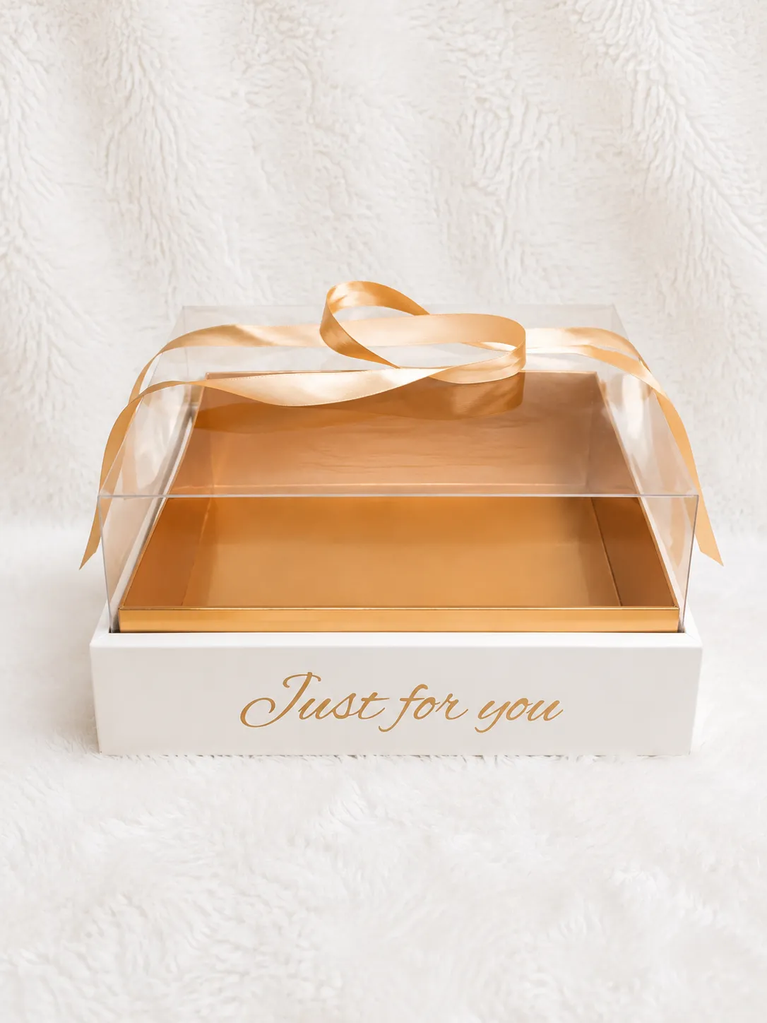  A white gift box adorned with a shiny gold ribbon, elegantly tied in a bow on top.<br />
